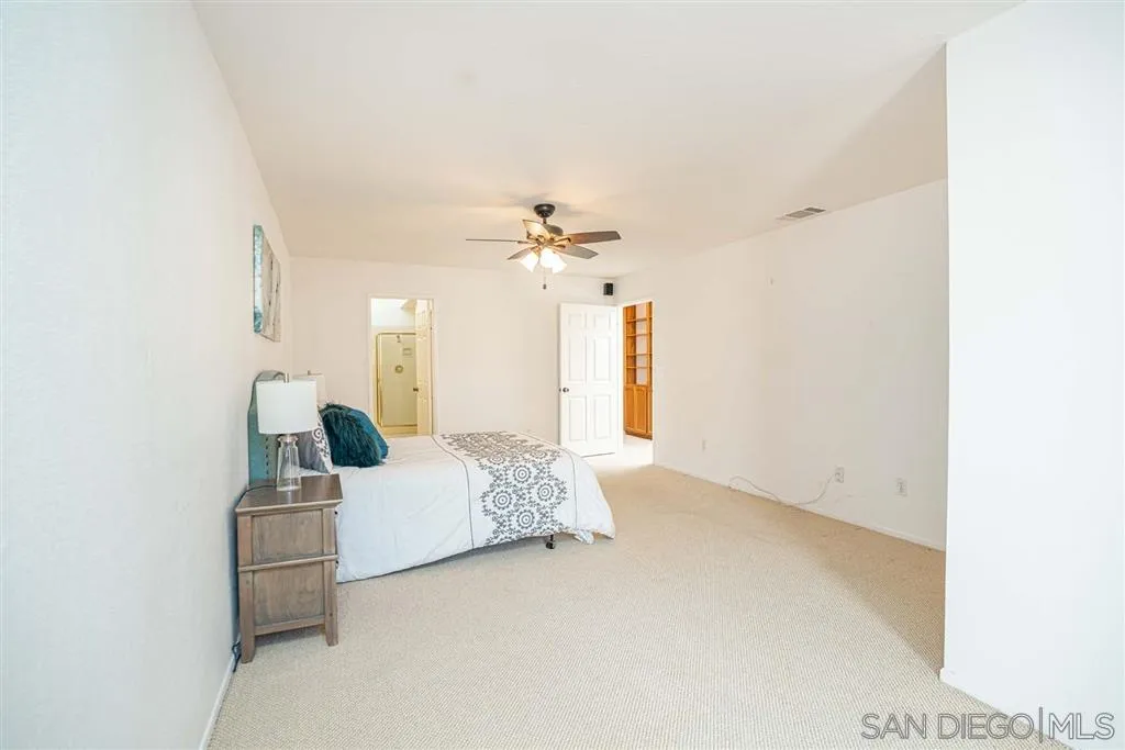 8549 Circle R Valley Lane Escondido, CA 92026 - Photo 13 of 25 a bedroom with a bed and a chandelier