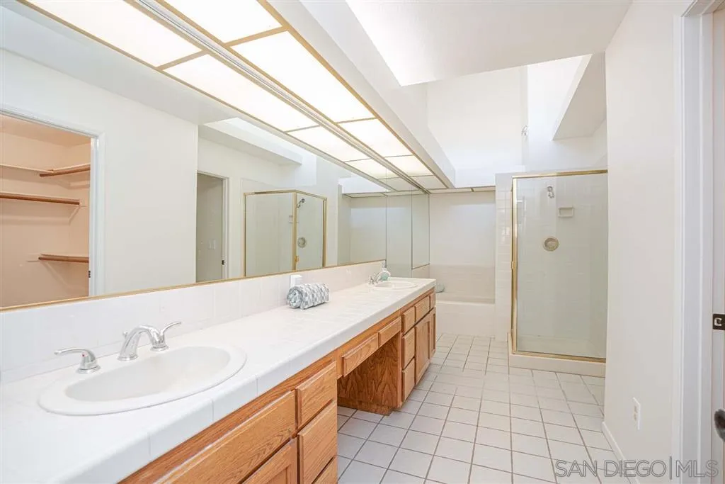 8549 Circle R Valley Lane Escondido, CA 92026 - Photo 15 of 25 a spacious bathroom with a sink a mirror and a shower