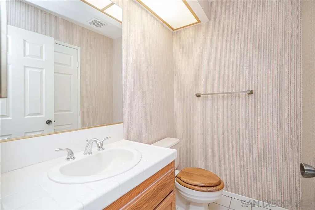 8549 Circle R Valley Lane Escondido, CA 92026 - Photo 18 of 25 a bathroom with a sink a toilet and a mirror