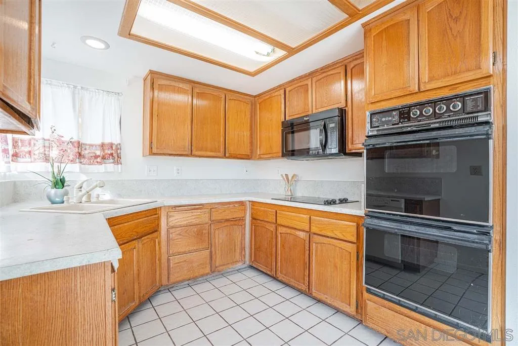8549 Circle R Valley Lane Escondido, CA 92026 - Photo 21 of 25 a kitchen with stainless steel appliances granite countertop a sink a stove and cabinets