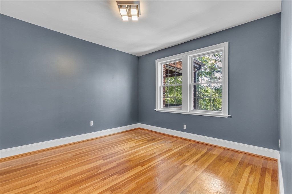 27 Newell Road, Unit 2 Brookline, MA 02446 - Photo 15 of 41 a view of an empty room with wooden floor and a window
