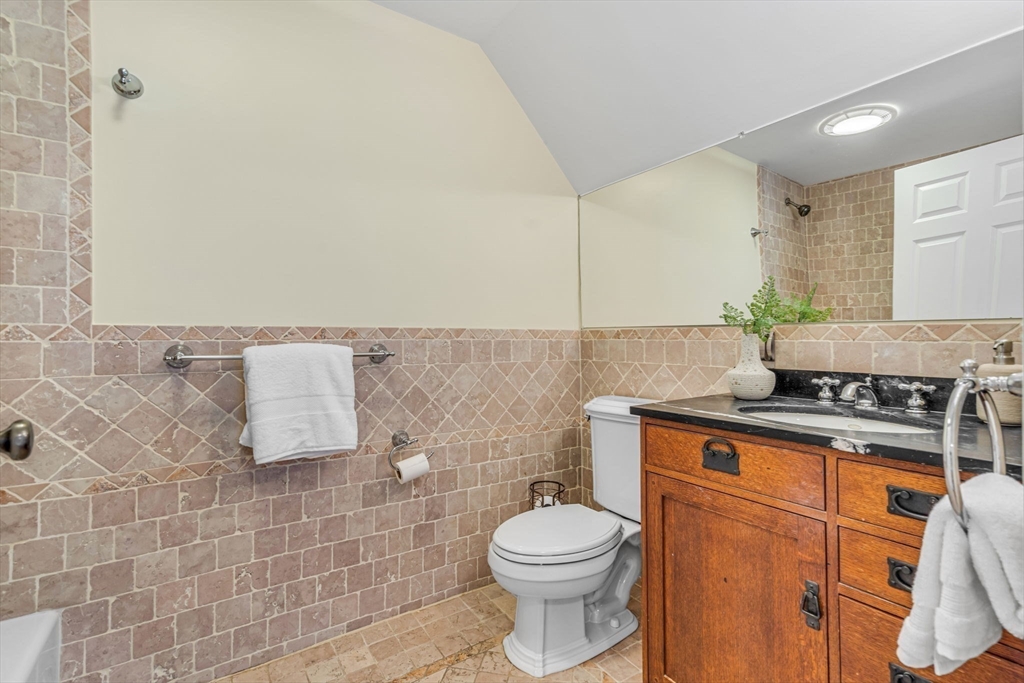 27 Newell Road, Unit 2 Brookline, MA 02446 - Photo 33 of 41 a bathroom with a granite countertop sink a toilet and a mirror