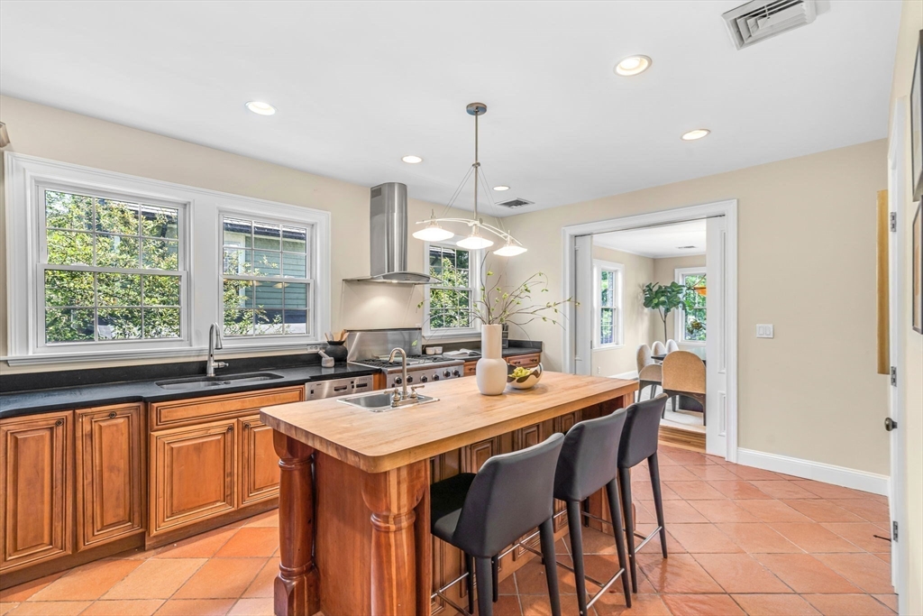 27 Newell Road, Unit 2 Brookline, MA 02446 - Photo 9 of 41 a kitchen with a stove a sink a dining table and chairs