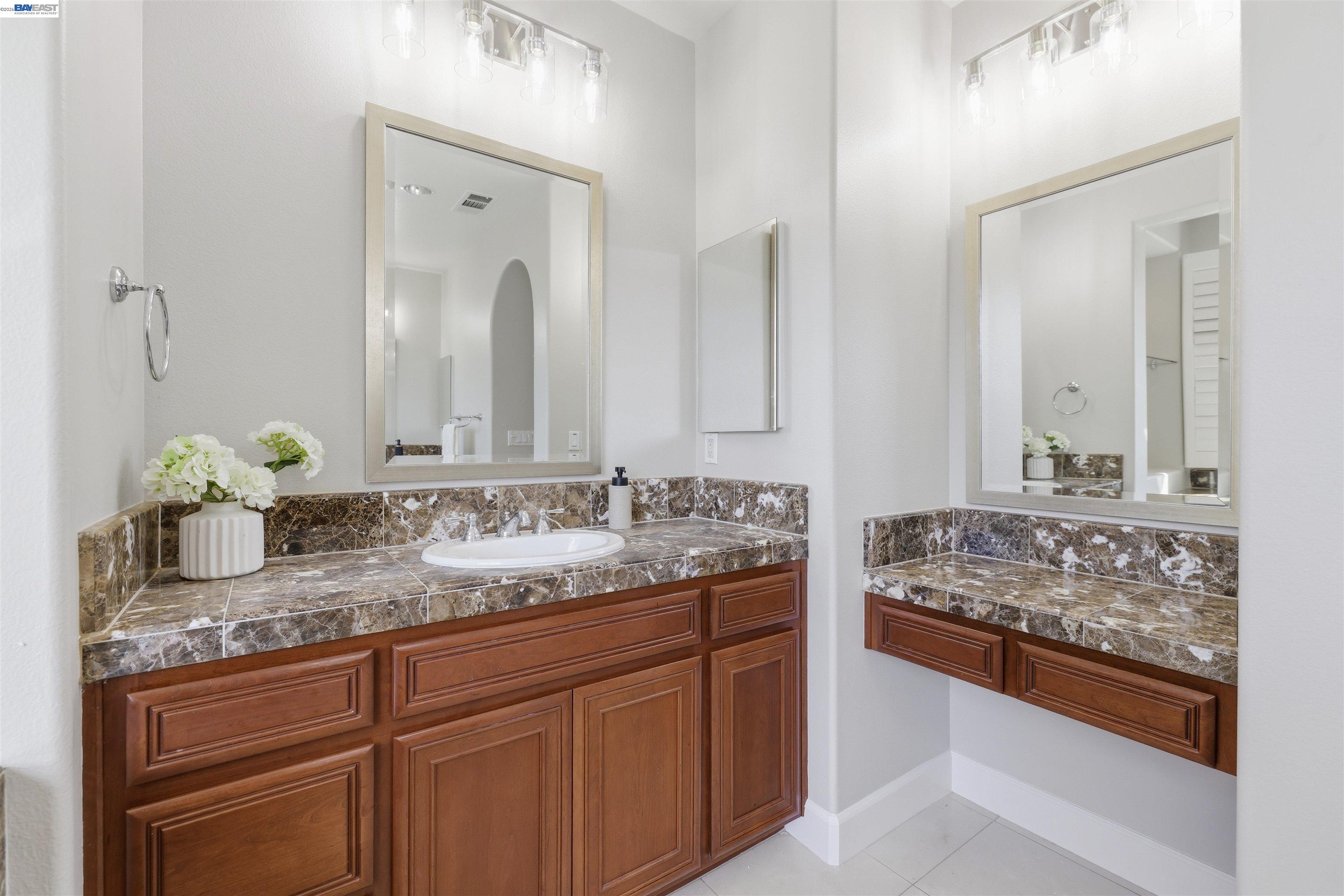 116 Macedon Court San Ramon, CA 94582 - Photo 42 of 60 a bathroom with double sink and a mirror