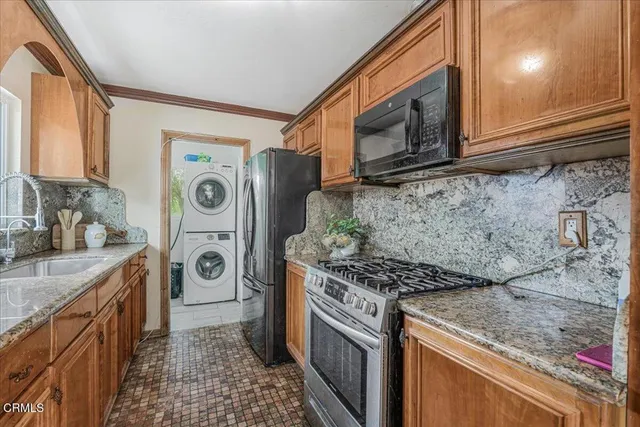 a kitchen with stainless steel appliances granite countertop a stove a washer and dryer