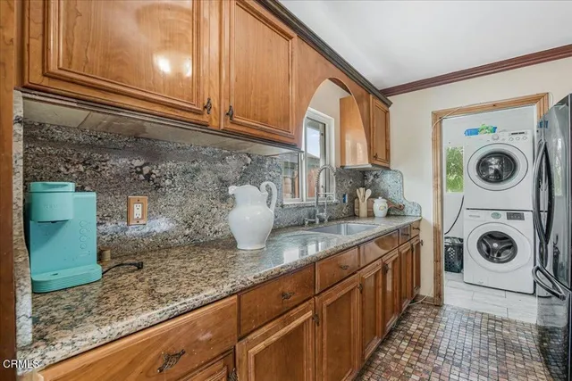 a kitchen with granite countertop a sink a stove and cabinets