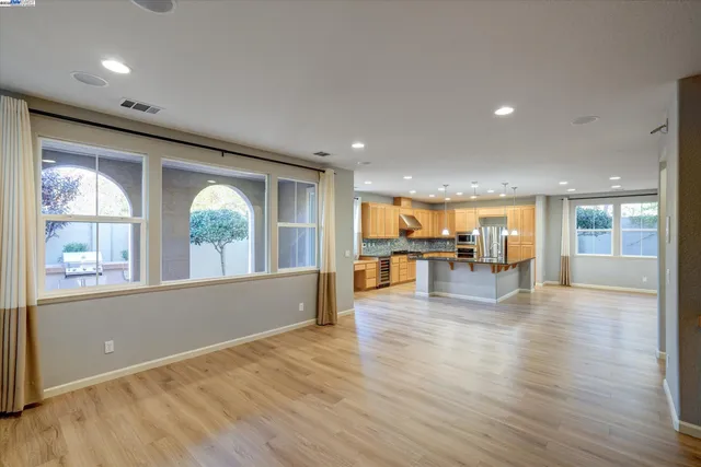 an empty room with wooden floor and natural light