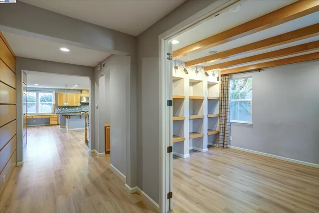 a view of a hallway with wooden floor and windows