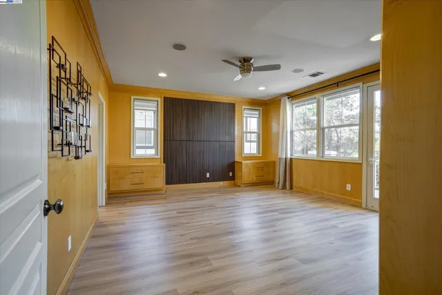 an empty room with wooden floor and windows