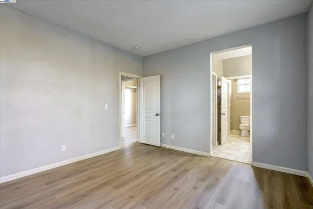 an empty room with wooden floor and a window