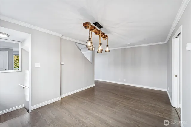 an empty room with wooden floor chandelier fan and windows
