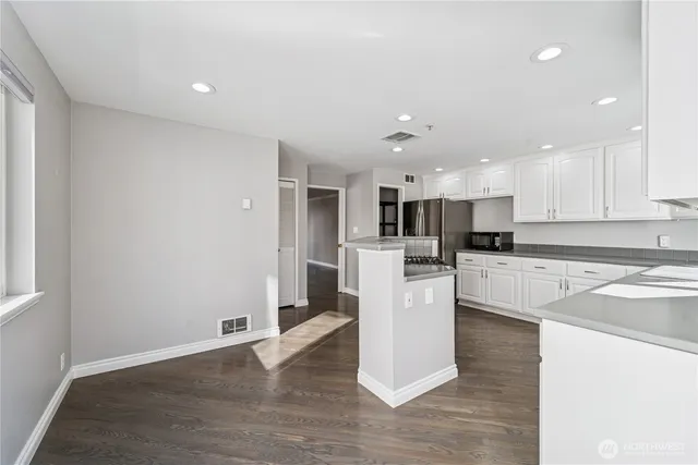 a kitchen with a refrigerator and a stove top oven