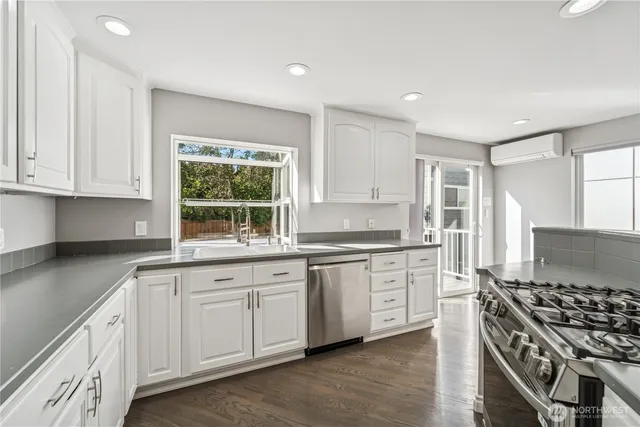 a kitchen with granite countertop white cabinets and a stove top oven