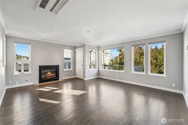 an empty room with floor to ceiling windows and fireplace