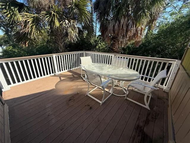 a view of a balcony with wooden floor and fence