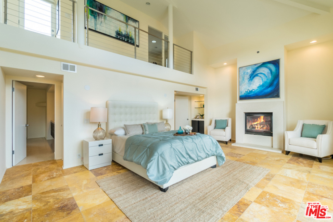 4515 Roma Court Marina del Rey, CA 90292 - Photo 16 of 31 a bedroom with a large bed a fireplace and baby couch