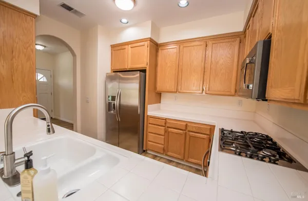 a kitchen with stainless steel appliances a refrigerator sink and cabinets