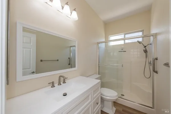 a bathroom with a sink a toilet and shower
