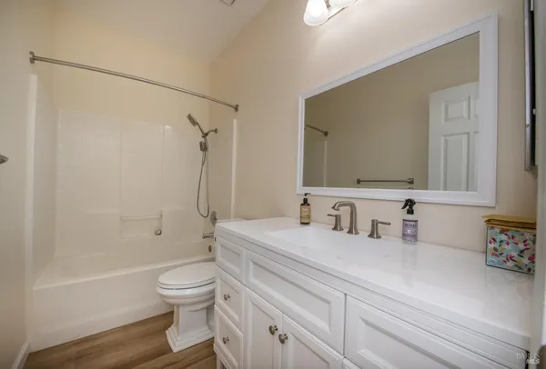a bathroom with a granite countertop sink a toilet a mirror and shower