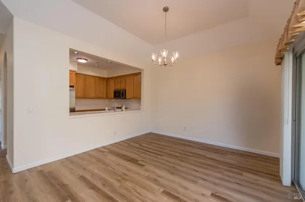a view of a hallway with wooden floor and chandelier