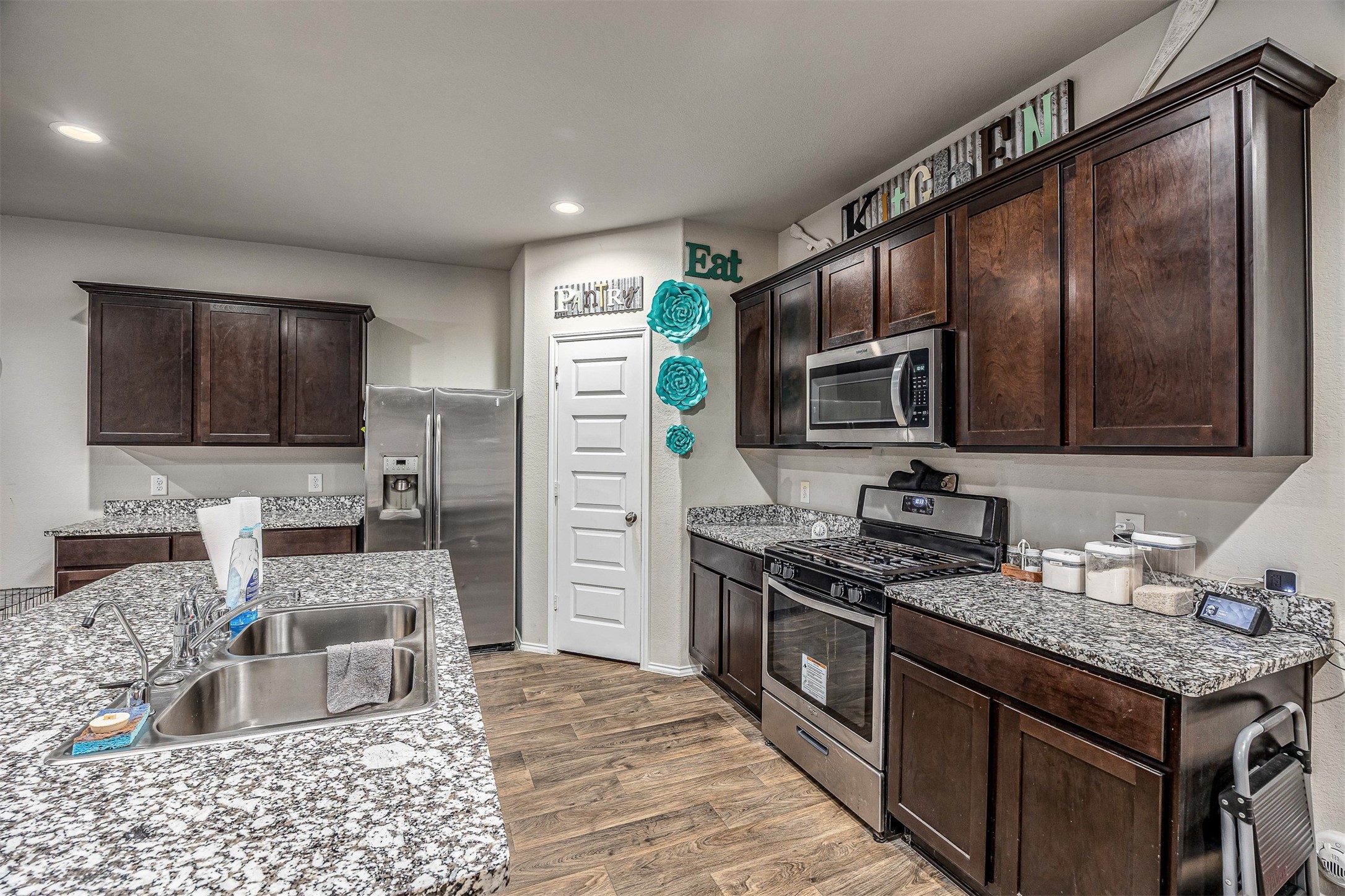 3907 Hawaiian Court Baytown, TX 77521 - Photo 20 of 40 a kitchen with stainless steel appliances granite countertop a stove top oven a sink dishwasher a refrigerator and a microwave