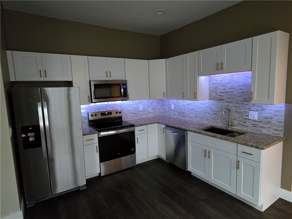 28 Ames Street Seneca, SC 29678 - Photo 10 of 22 Granite countertops and white cabinetry define this functional kitchen workspace.