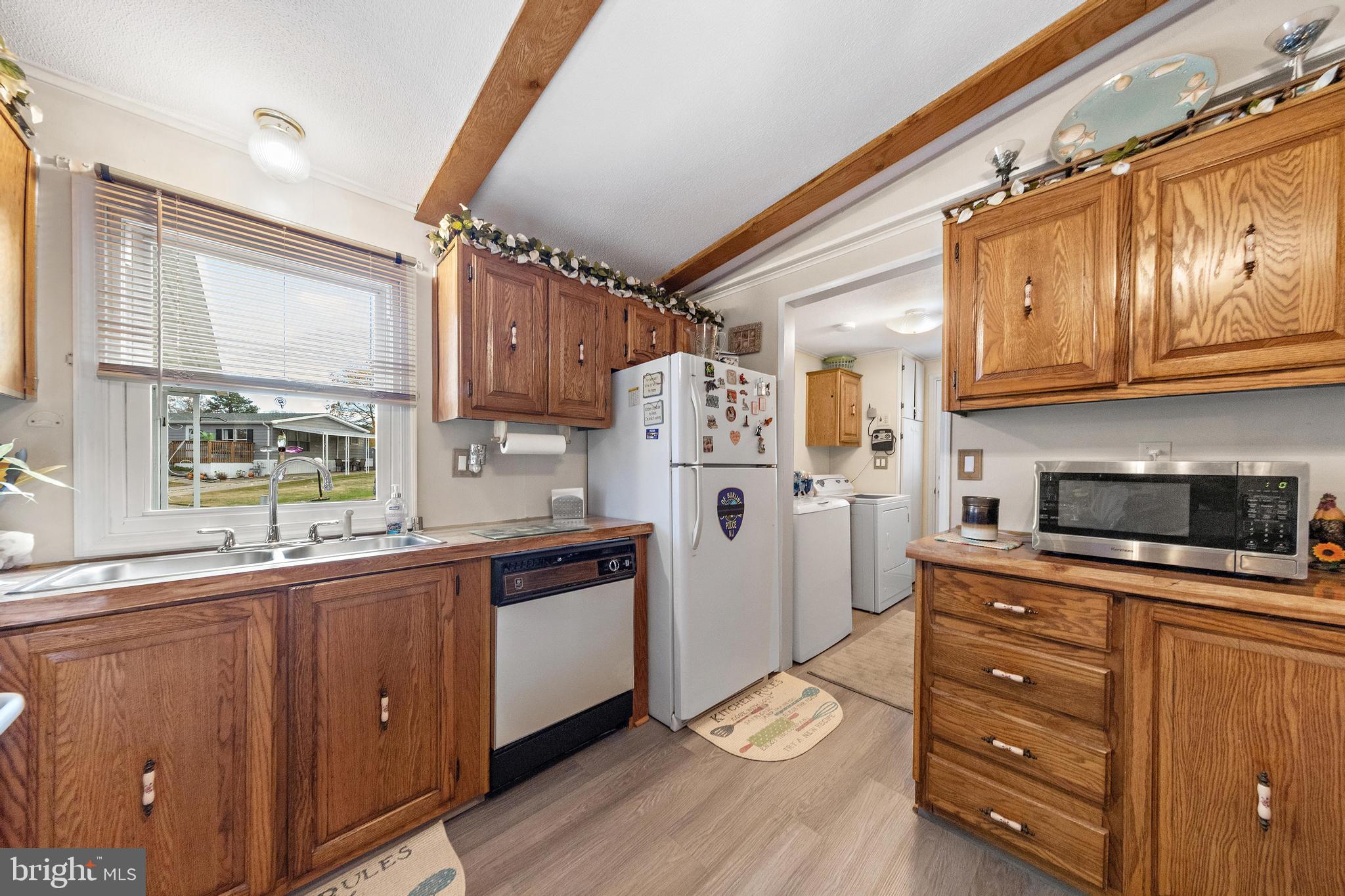 154 Brighton Road Barnegat, NJ 08005 - Photo 18 of 44 a kitchen with stainless steel appliances a refrigerator a sink and wooden floors