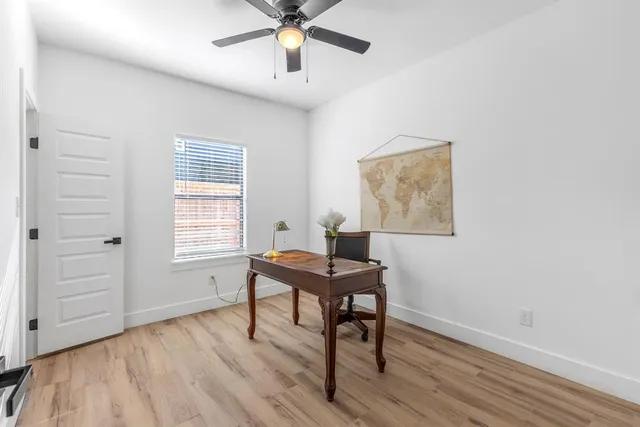 a view of a workspace with furniture and wooden floor