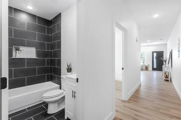 a bathroom with a toilet a sink a rug and bathtub