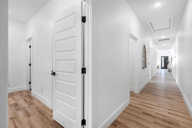 a view of a hallway with wooden floor and closet area