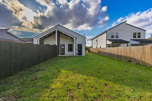a view of a house with a big yard plants and large tree