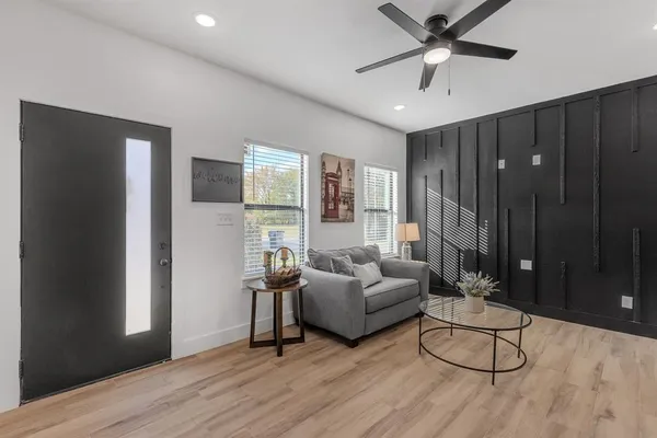 a living room with furniture and a hard wood floor