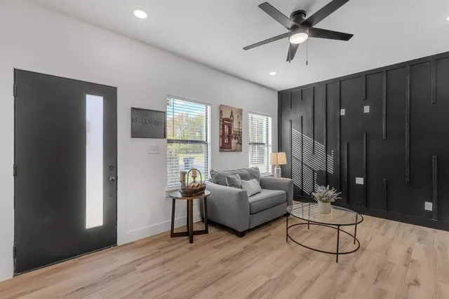 a living room with furniture and a hard wood floor