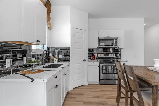 a kitchen with stainless steel appliances a stove a sink a microwave and wooden cabinets