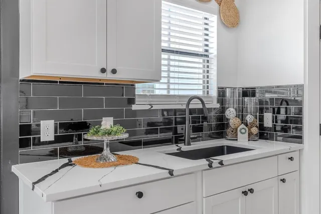 a kitchen with a sink and a stove next to a window