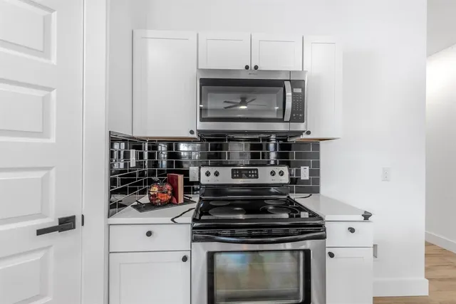 a stove top oven sitting inside of a kitchen