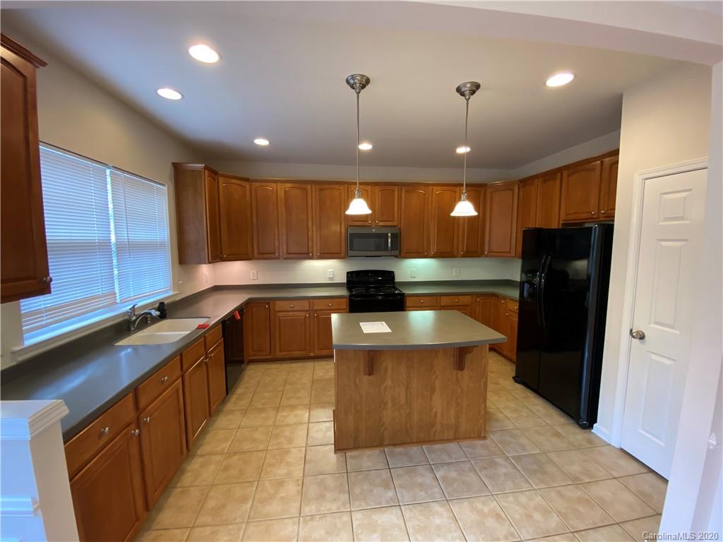 2736 Laurel Cherry Street Raleigh, NC 27612 - Photo 3 of 14 a large kitchen with stainless steel appliances kitchen island granite countertop a sink a stove and a refrigerator