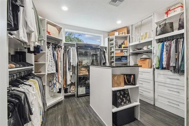a view of a white house with a big yard and potted plants