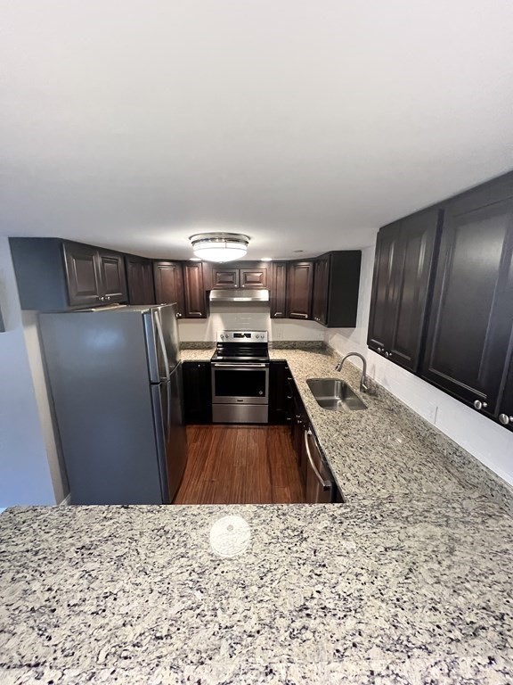 166 Pleasant Street, Unit 1 Marblehead, MA 01945 - Photo 3 of 10 a kitchen with stainless steel appliances granite countertop a sink stove and refrigerator