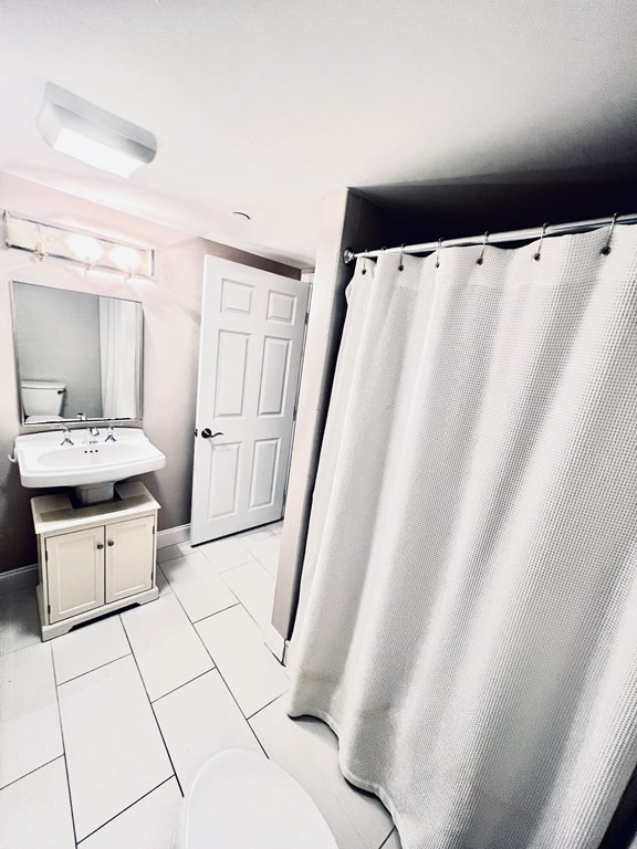166 Pleasant Street, Unit 1 Marblehead, MA 01945 - Photo 8 of 10 a bathroom with a bathtub sink and toilet