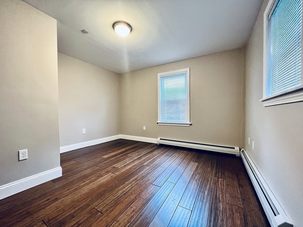 166 Pleasant Street, Unit 1 Marblehead, MA 01945 - Photo 9 of 10 an empty room with wooden floor and windows
