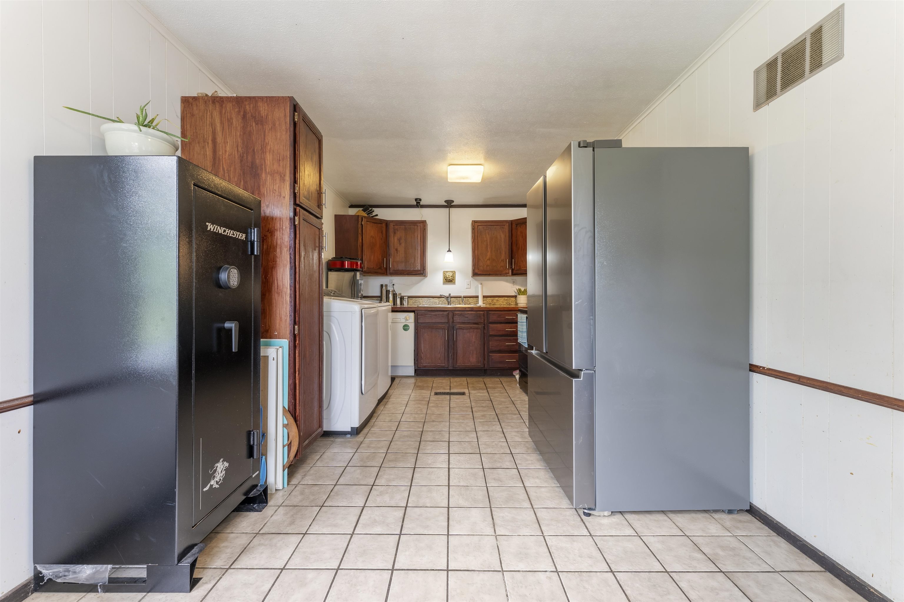 17 Walnut Road Munford, TN 38058 - Photo 15 of 20 Kitchen featuring freestanding refrigerator, washer / clothes dryer, wood finish cabinets, decorative light fixtures, and light tile patterned floors