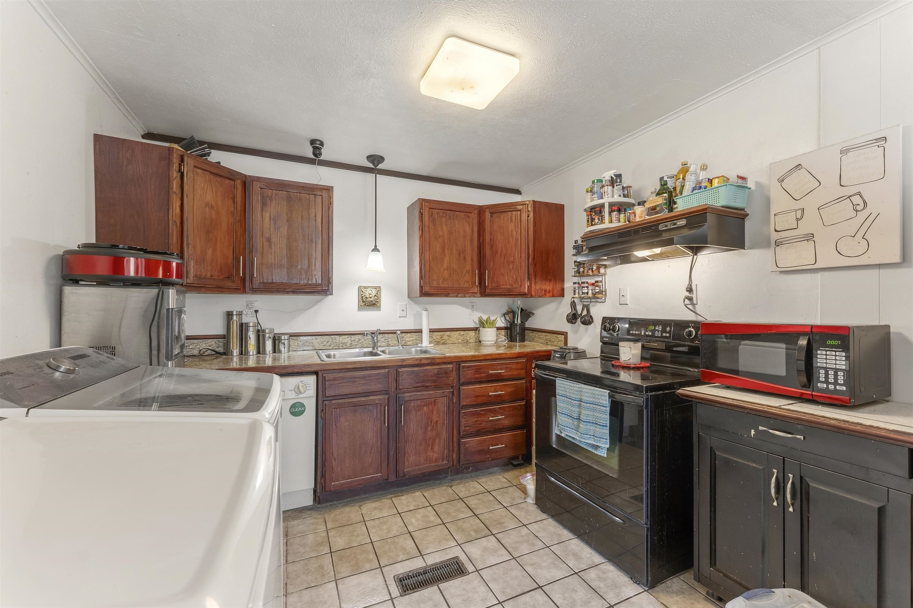 17 Walnut Road Munford, TN 38058 - Photo 16 of 20 Kitchen with black range with electric stovetop, pendant lighting, crown molding, light tile patterned flooring, and dishwasher