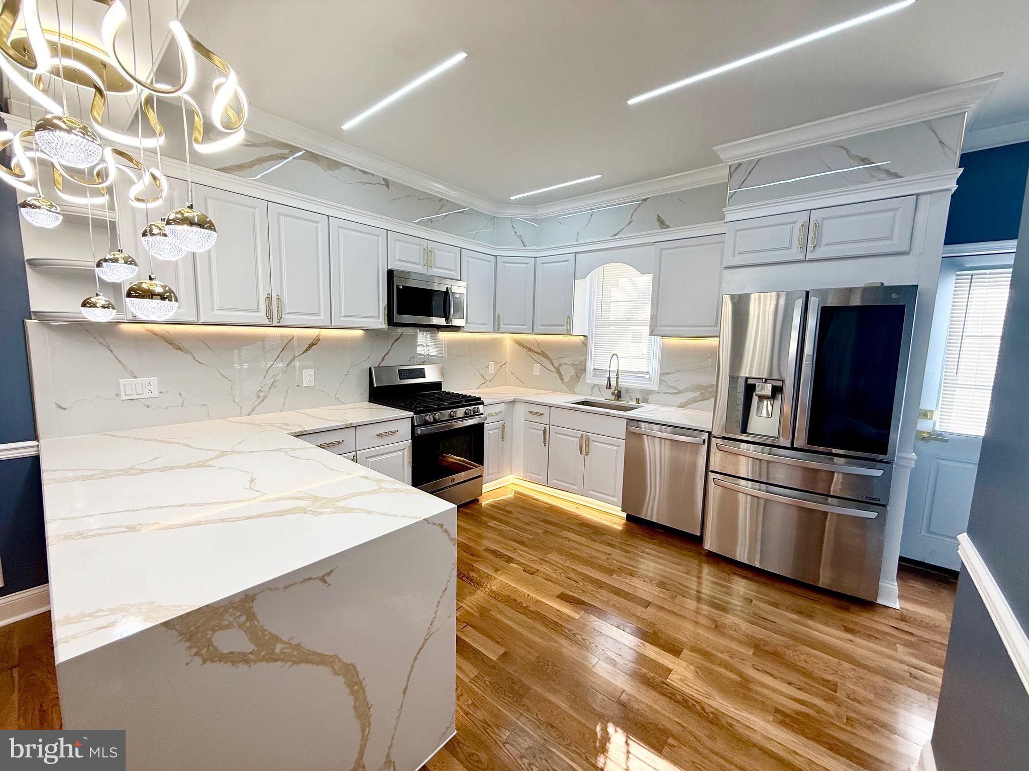 1942 South 56th Street Philadelphia, PA 19143 - Photo 9 of 36 a kitchen with a sink stainless steel appliances and white cabinets