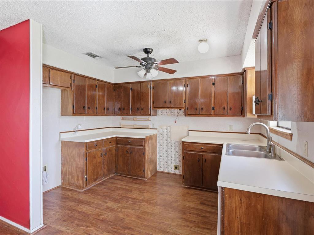 701 College Street Celeste, TX 75423 - Photo 11 of 29 a kitchen with granite countertop a sink a stove and cabinets