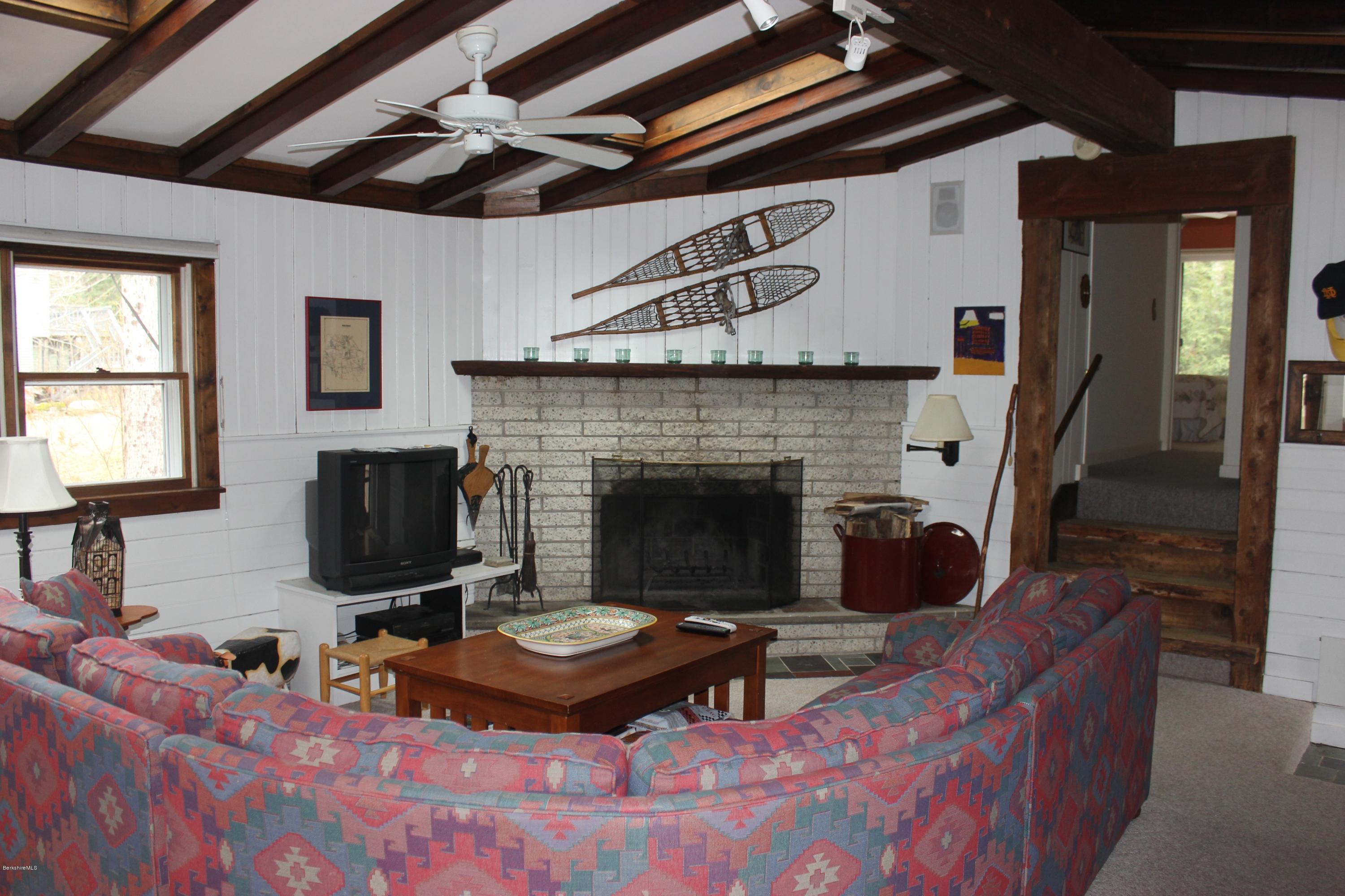 40 Williams Road Becket, MA 01223 - Photo 6 of 18 a living room with furniture a flat screen tv and a fireplace