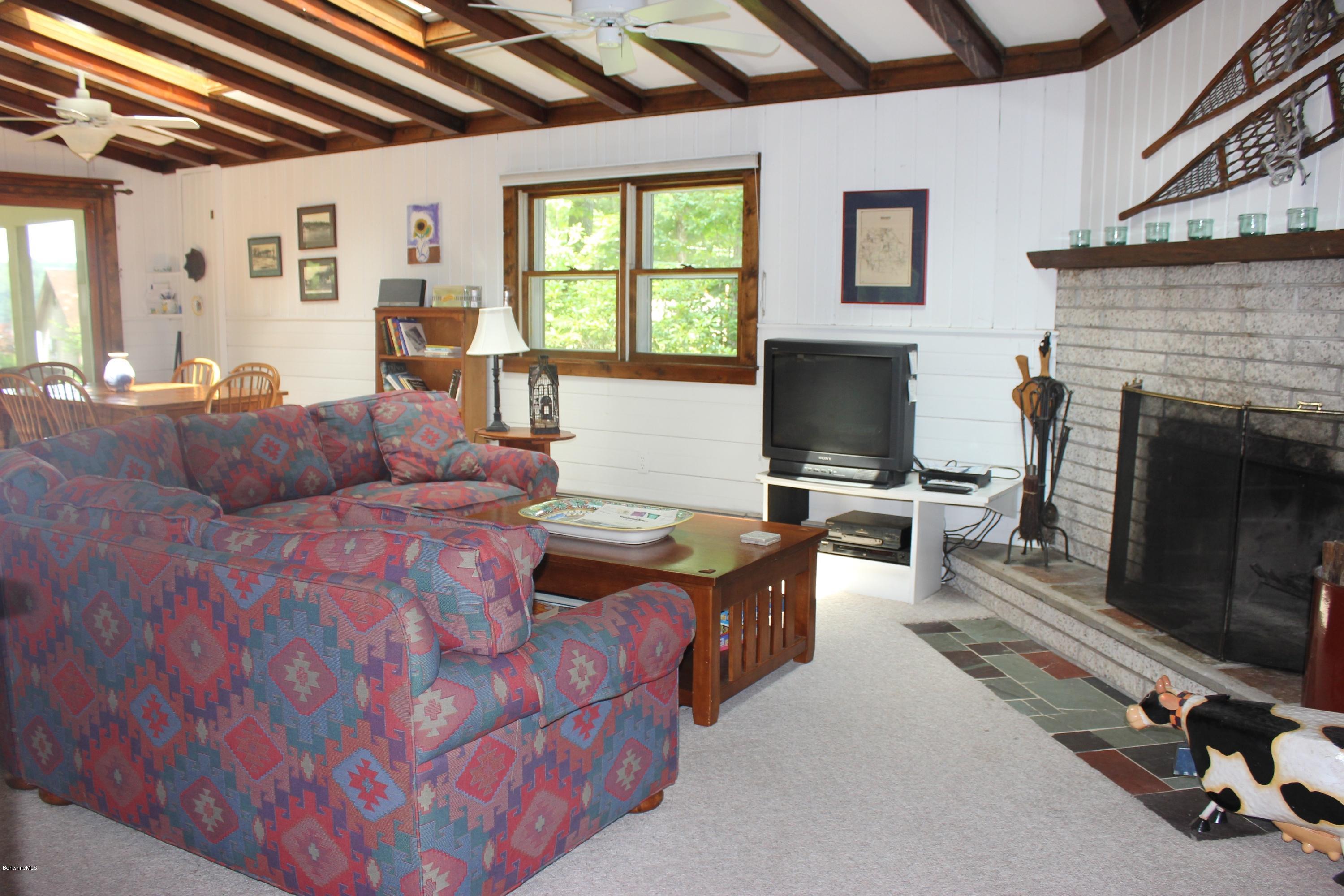 40 Williams Road Becket, MA 01223 - Photo 7 of 18 a living room with furniture a flat screen tv and a fireplace