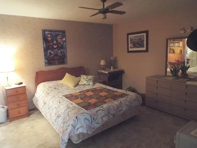 a bedroom with a bed and painting on the wall