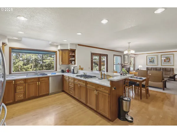 a kitchen with stainless steel appliances granite countertop a refrigerator a sink dishwasher a stove with large oven next to a window