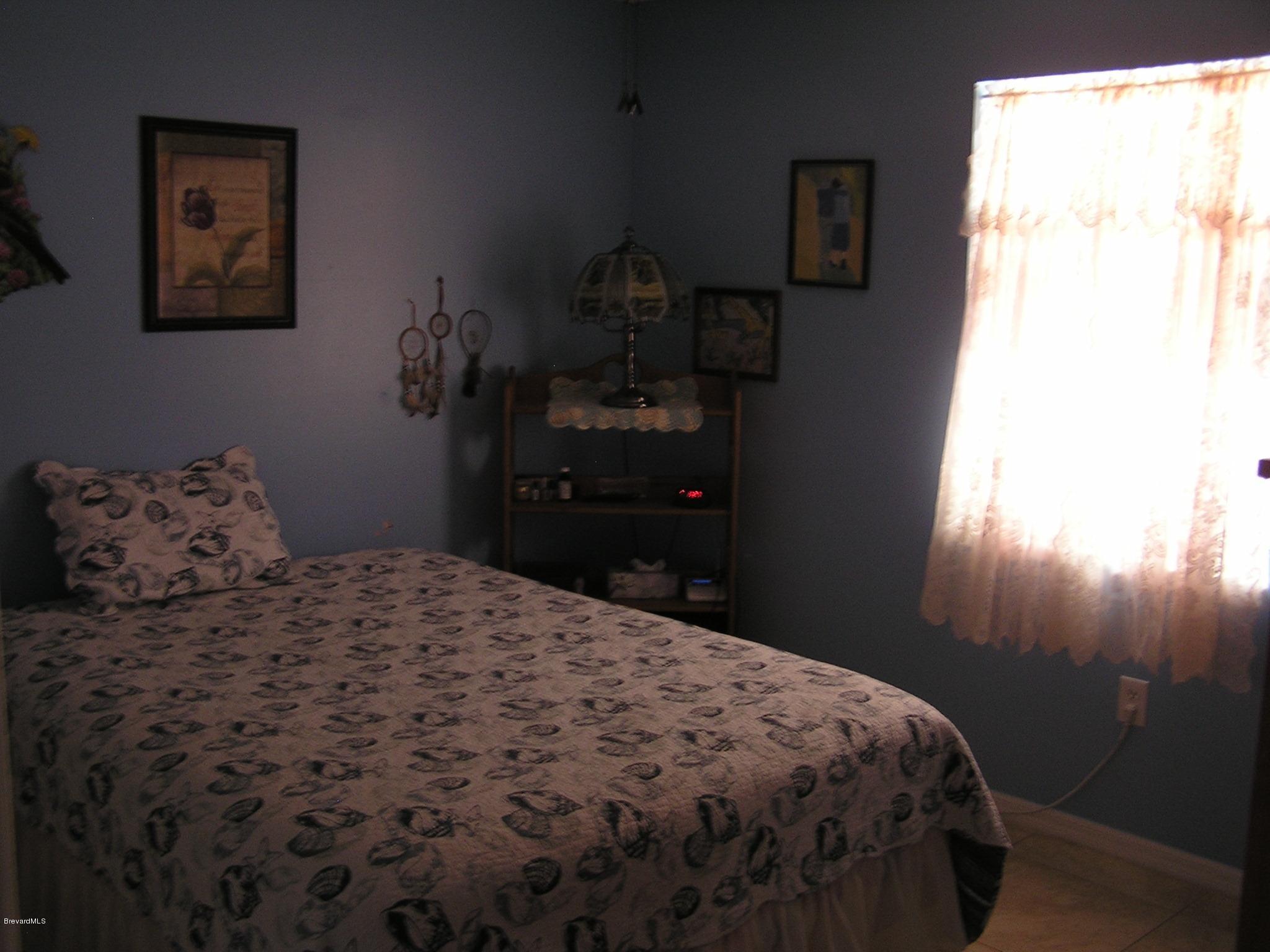 6474 Hudson Road Cocoa, FL 32927 - Photo 6 of 9 a bedroom with a bed and a window